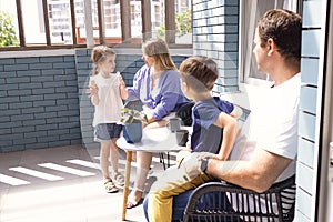 Happy family having breackfast coffee on rooftop patio at home in the morning photo