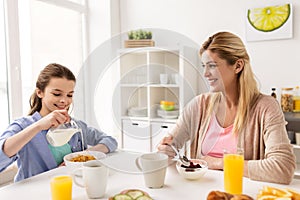 Happy family having breakfast at home kitchen