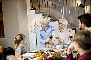 Happy family having dinner with red wine at home