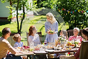 Happy family having dinner or summer garden party