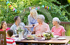 Happy family having dinner or summer garden party