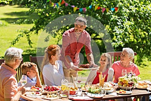 Happy family having dinner or summer garden party