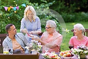 Happy family having dinner or summer garden party