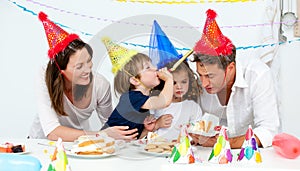 Familia feliz con mientras comer pastel de cumpleanos 