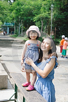 Happy family having fun with animals safari park on warm summer day