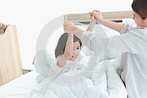 Happy family having fun in the bedroom. Mother, and daughter spending time together, little girl playing with her mom on bed,