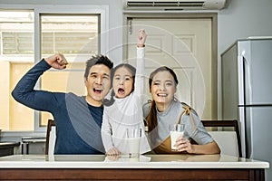 Happy family having fun in the kitchen. Asian Father, mother and little daughter spending time together and having breakfast