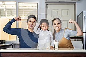 Happy family having fun in the kitchen. Asian Father, mother and little daughter spending time together and having breakfast