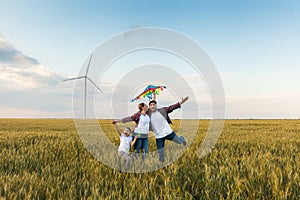 Happy family having fun with kite on the field