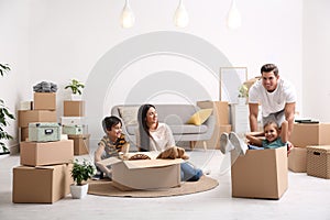 Happy family having fun while moving boxes at their new home