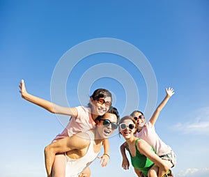 Happy family having fun outdoors against blue sky