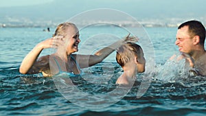 Happy family having fun in sea water