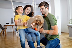 Happy family having fun time, playing together at home with dog