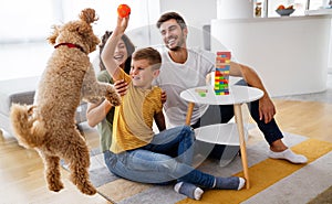 Happy family having fun time, playing together at home with dog