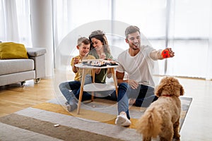 Happy family having fun time, playing together at home with dog