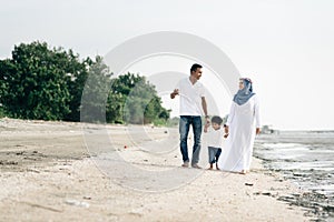 Happy family having fun time walking together at the beach located in Pantai Remis