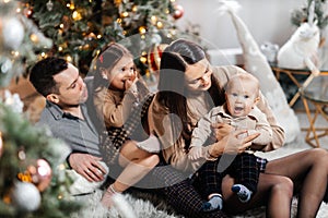 Happy family having fun together against the background of a New Year tree and Christmas decor