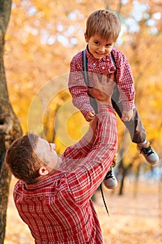 Happy family having holiday in autumn city park. Children and parents posing, smiling, playing and having fun. Bright yellow trees