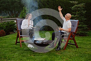 Happy family having late evening barbecue picnic