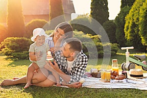 Happy family having picnic in garden on sunny day