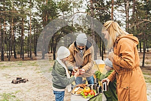 happy family having picnic on nature on cold