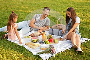 Happy family having picnic in park on summer day