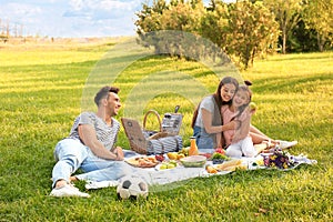 Happy family having picnic in park on summer day