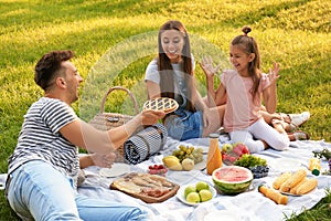 Happy family having picnic in park on summer day