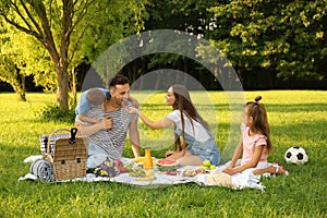 Happy family having picnic in park on summer day