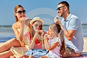 Happy family having picnic on summer beach