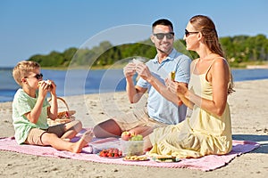 Happy family having picnic on summer beach