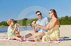 Happy family having picnic on summer beach