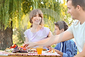 Happy family having picnic on summer day