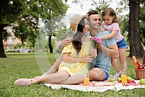 Happy family having picnic in  on summer day