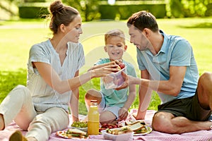 Happy family having picnic at summer park