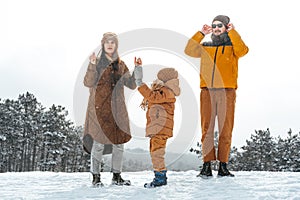 Happy family having a walk in winter outdoors in snow