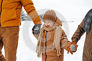 Happy family having a walk in winter outdoors in snow