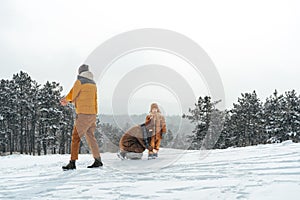 Happy family having a walk in winter outdoors in snow