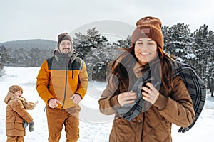 Happy family having a walk in winter outdoors in snow