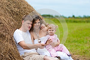 Happy family in haystack or hayrick