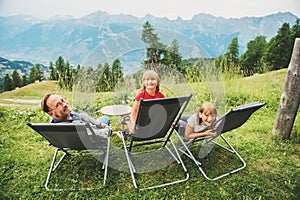 Happy family hiking in swiss Alps, enjoying amazing view, travel with kids