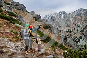 Happy family hiking together in autumn mountains.