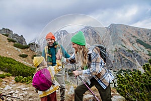 Šťastná rodinná turistika společně v podzimních horách.