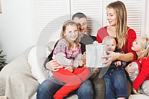 Happy family holding christmas gifts at home