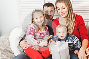 Happy family holding christmas gifts at home