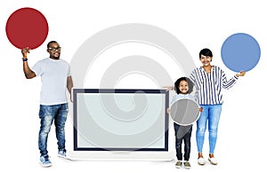 Happy family holding round boards and a screen