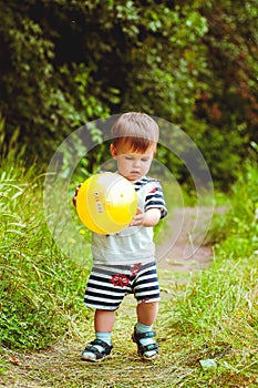 Happy family and holiday concept. Little boy in a sailor suit sitting on mother hands and laughing on a summer sunny day.