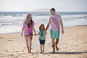 Happy family holidays. Father, mother and son child walking on sand beach. Summer vacations with children.