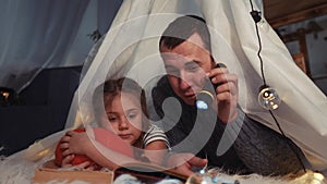 Happy family at home dream. Dad and daughter happy family at home reading a book in the evening in stay home homemade