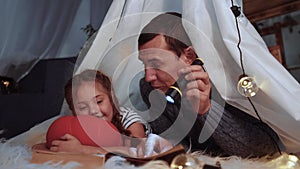 happy family at home dream. dad and daughter happy family at home reading a book in the evening in stay home lockdown